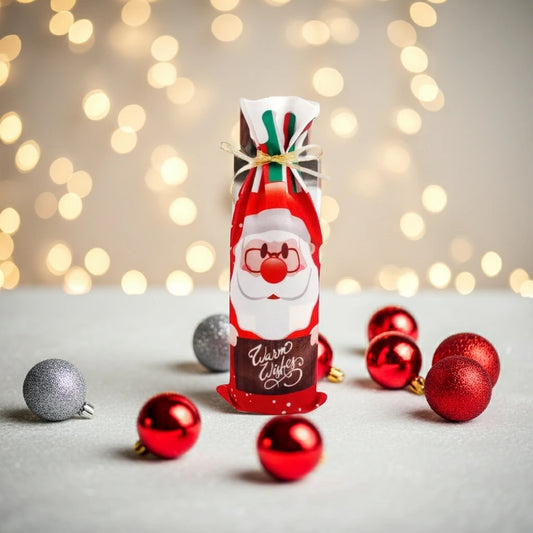 Einzelne Stoff-Flaschenhülle im Weihnachtsmann-Design, umgeben von roten und silbernen Weihnachtskugeln auf glitzerndem Untergrund.