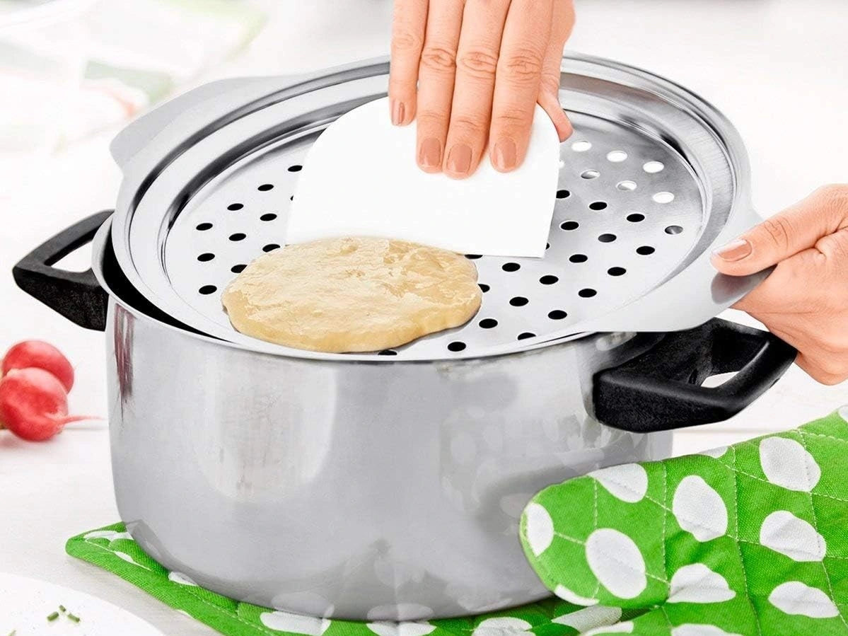 Spätzlesieb aus Edelstahl 18/10 mit weisser Teigkarte, aufgelegt auf einem Kochtopf für einfache Spätzle-Herstellung.