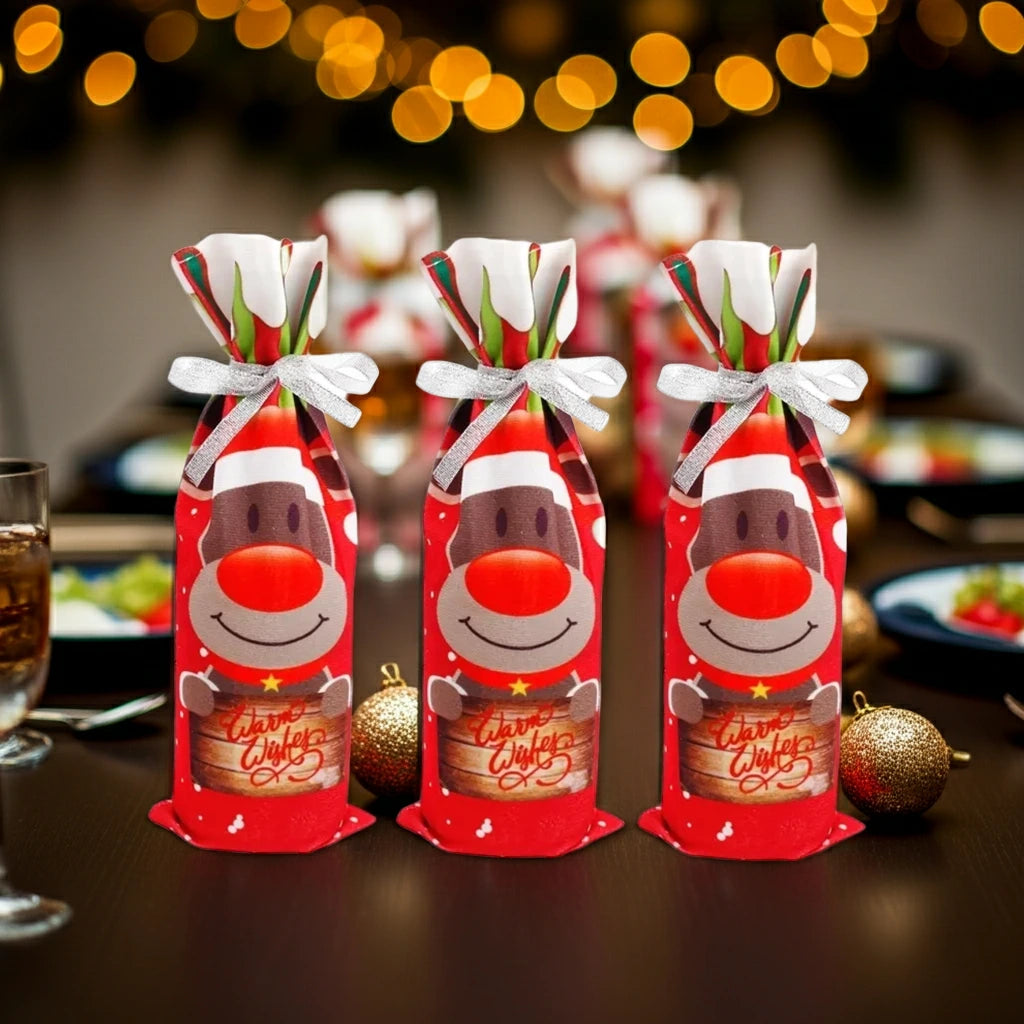 Drei identische Stoff-Flaschenhüllen mit Rentier-Design, stehend auf einem festlich gedeckten Tisch mit Lichterkette im Hintergrund.